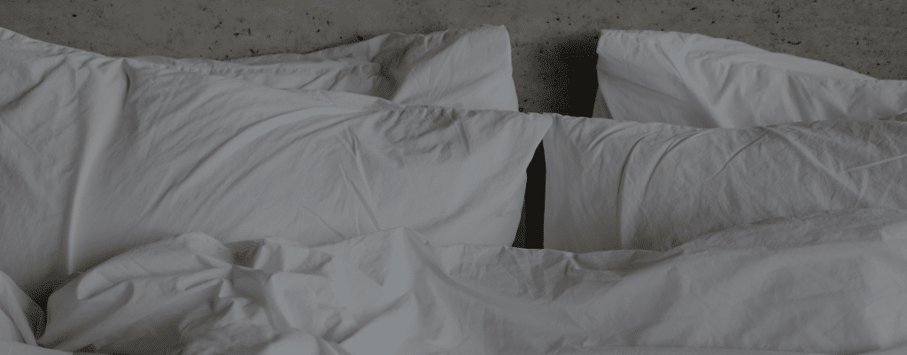 Messy white bed with pillows
